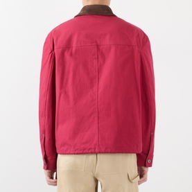 Model wearing Loewe red cotton casual jacket, rear view, with contrast brown collar and snap cuff detail, styled with beige trousers