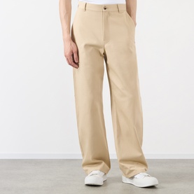 Model wearing Loewe beige cotton casual trousers with wide-leg fit, styled with white trainers.