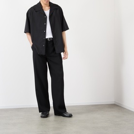 Model wearing Loewe Solid Camp Shirt in black with matching wide-leg trousers and black leather shoes.