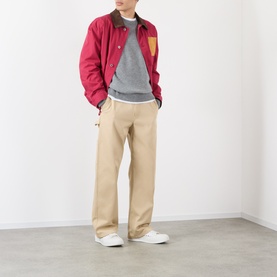 Model wearing Loewe Anagram Logo Sweater in Grey Melange crew neck, styled with red bomber jacket and beige trousers.