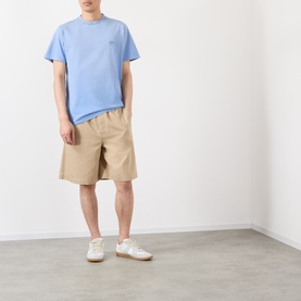 Model wearing Loewe Tonal Anagram Logo T-Shirt in blue with beige shorts and white trainers.