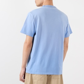 Model wearing Loewe Tonal Anagram Logo T-Shirt in blue, rear view showing crew neck, short sleeves and straight hem. Styled with beige trousers.