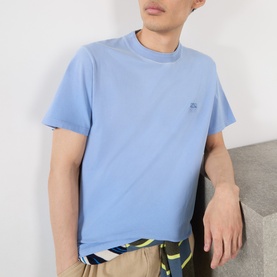 Model wearing Loewe Tonal Anagram Logo T-Shirt in blue, crew neck, short sleeves, with tonal chest logo embroidery. Styled with printed shorts.