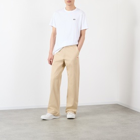 Model wearing Loewe white cotton T-shirt with beige wide-leg trousers and white trainers.