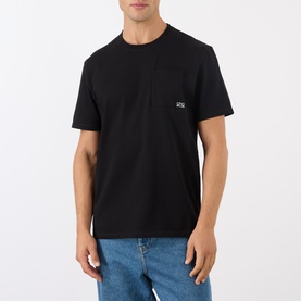 Model wearing Loewe black cotton T-shirt with small chest logo patch, styled with blue jeans.