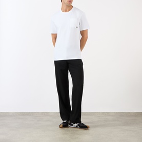 Model wearing Loewe Anagram Logo Chest Pocket T-Shirt in white with black trousers and dark trainers.