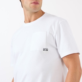 Model wearing Loewe Anagram Logo Chest Pocket T-Shirt in white, featuring embroidered logo detail on chest pocket and round neck.