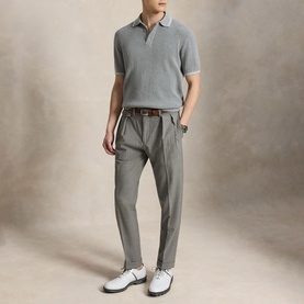 Model wearing RLX Golf knit polo in Spring Heather and Stone Pebble, styled with grey trousers and white golf shoes.