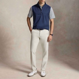 Model wearing RLX Golf Logo Quarter-Zip Gilet in Spring Navy Heather, styled with a grey polo shirt, cream trousers, and white shoes.