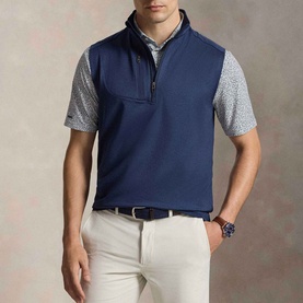 Model wearing RLX Golf Logo Quarter-Zip Gilet in Spring Navy Heather with a grey printed short-sleeve polo and cream chinos.