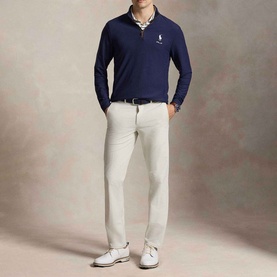 Model wearing RLX Golf Pony Logo Mesh Quarter-Zip Sweatshirt in Refined Navy with light grey trousers and white shoes.