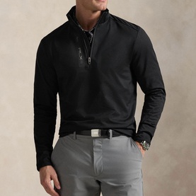 Model wearing RLX Golf black quarter-zip sweatshirt with stand collar, styled with grey trousers and a belt.