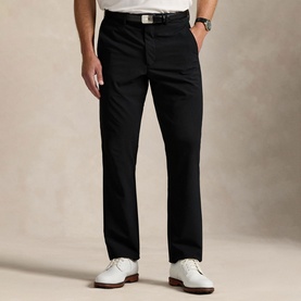 Model wearing RLX Golf trousers in Polo Black, straight leg fit, styled with a black belt and white golf shoes.