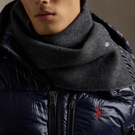 Model wearing a grey knit scarf styled with a navy quilted down jacket with zip detail.