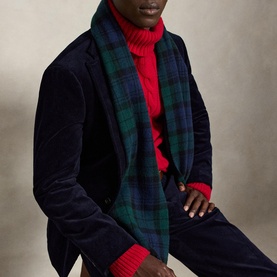 Model wearing navy blazer and red rollneck, styled with a green and navy blue tartan plaid scarf