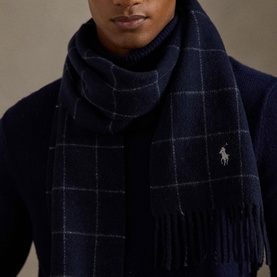 Model with navy blue windowpane check fringed scarf with embroidered polo pony logo, styled with matching navy knit sweater