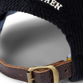 Ralph Lauren black corduroy cap, close-up of brown leather strap with gold-tone buckle adjuster and embroidered logo detail