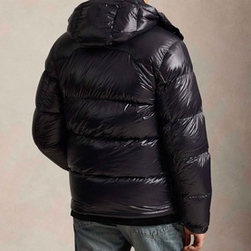 Model wearing Ralph Lauren Polo Black Glossy quilted puffer jacket with hood, rear view showing high-shine finish and ribbed cuffs.