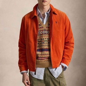Model wearing Ralph Lauren College Orange casual jacket over patterned knit vest, blue shirt, and khaki trousers