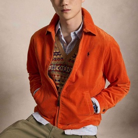 Model wearing Ralph Lauren College Orange corduroy casual jacket with navy logo, layered over patterned knit and striped shirt