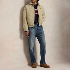 Model wearing Ralph Lauren Khaki Uniform casual jacket over striped navy top, styled with blue distressed jeans and tan loafers.