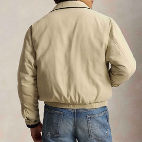 Model wearing Ralph Lauren casual jacket in khaki uniform, rear view, with dark collar trim and elasticated hem, styled with blue jeans.