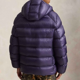Model wearing Ralph Lauren junberry quilted hooded puffer jacket, rear view showing horizontal baffle stitching and glossy finish.