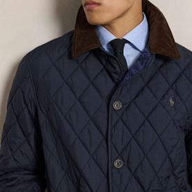 Model wearing Ralph Lauren navy quilted casual jacket with brown corduroy collar, styled with light blue shirt and dark tie