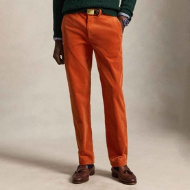 Model wearing Ralph Lauren Pony Logo Straight Leg Corduroy Trousers in Charles Orange, styled with a green knit and brown loafers