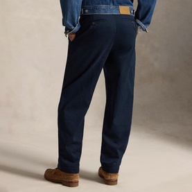 Model wearing Ralph Lauren aviator navy chino trousers, styled with a denim jacket and brown suede shoes, rear view.