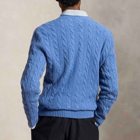 Model wearing Ralph Lauren cable-knit crew neck jumper in Turquoise Jay Heather, styled with white collared shirt and dark trousers, back view.