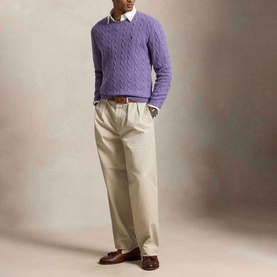 Model wearing Ralph Lauren Pony Logo Cable Knitted Sweater in light coronet purple heather, styled with white shirt, beige chinos and brown loafers.