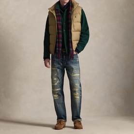 Model wearing Ralph Lauren Desert Khaki quilted down gilet over green sweatshirt and plaid shirt, styled with distressed jeans and brown boots.