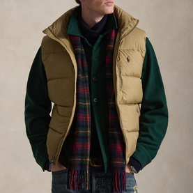 Model wearing Ralph Lauren Desert Khaki quilted gilet over green knit, styled with a tartan scarf