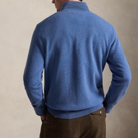 Model wearing blue marl half-zip knit sweater, back view, styled with brown herringbone trousers