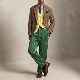 Model wearing Ralph Lauren Polo Player Logo Striped Shirt in Rugby Royal White, styled with green trousers, houndstooth blazer and yellow cardigan.