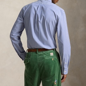 Model wearing Ralph Lauren Polo Player Logo Striped Shirt in Rugby Royal White, styled with green corduroy trousers and brown belt. Back view.