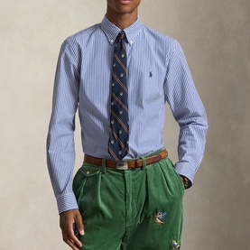 Model wearing Ralph Lauren Polo Player Logo Striped Shirt in Rugby Royal White, styled with a patterned tie and green trousers