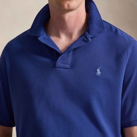 Model wearing Ralph Lauren Pony Logo Slim Fit Mesh Polo Shirt in Blue Yacht, showing embroidered Pony logo and ribbed collar detail.