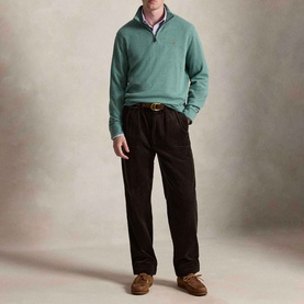 Model wearing Ralph Lauren Pine Heather half-zip sweatshirt, styled with dark trousers, pink shirt, and brown suede loafers.