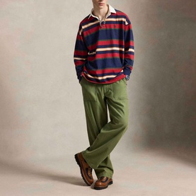 Model wearing Ralph Lauren Pony Logo Striped Rugby Shirt in Newport Navy Multi, styled with olive wide-leg trousers and brown boots.