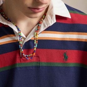 Model wearing Ralph Lauren Pony Logo Striped Rugby Shirt in Newport Navy Multi with multicolour beaded necklace.