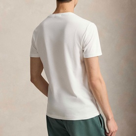 Model wearing Ralph Lauren Polo Bear Custom Slim Fit T-Shirt in white, rear view, crew neck, short sleeves, styled with green shorts.