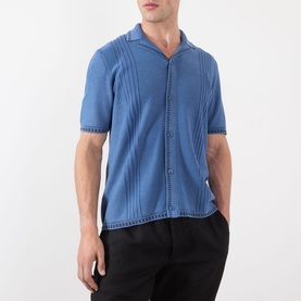 Model wearing Wax London Ivy Washed Shirt in blue, camp collar, short sleeves, textured stripe detail, button fastening, styled with black trousers