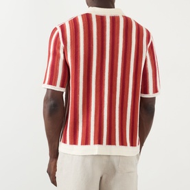 Model wearing Wax London Porto Striped Cardigan in ecru and orange, rear view, paired with light grey trousers.