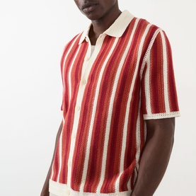 Model wearing Wax London Porto Striped Cardigan in ecru and orange, short-sleeve knit with polo collar and vertical stripe pattern.