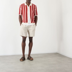 Model wearing Wax London Porto Striped Cardigan in ecru and orange, styled with cream shorts and tan sandals