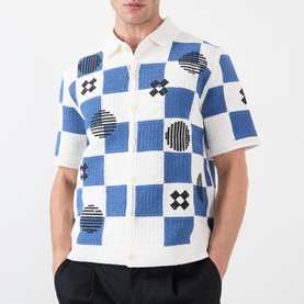 Model wearing Wax London Porto Printed Cardigan in ecru and blue checkerboard pattern with geometric motifs, short sleeves and button fastening.