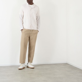 Model wearing Wax London Corey Striped Shirt in Natural, long sleeves, pointed collar, styled with beige trousers and white trainers.