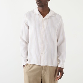 Model wearing Wax London Corey Striped Shirt in Natural, long sleeve cotton shirt with pointed collar, styled with beige trousers.